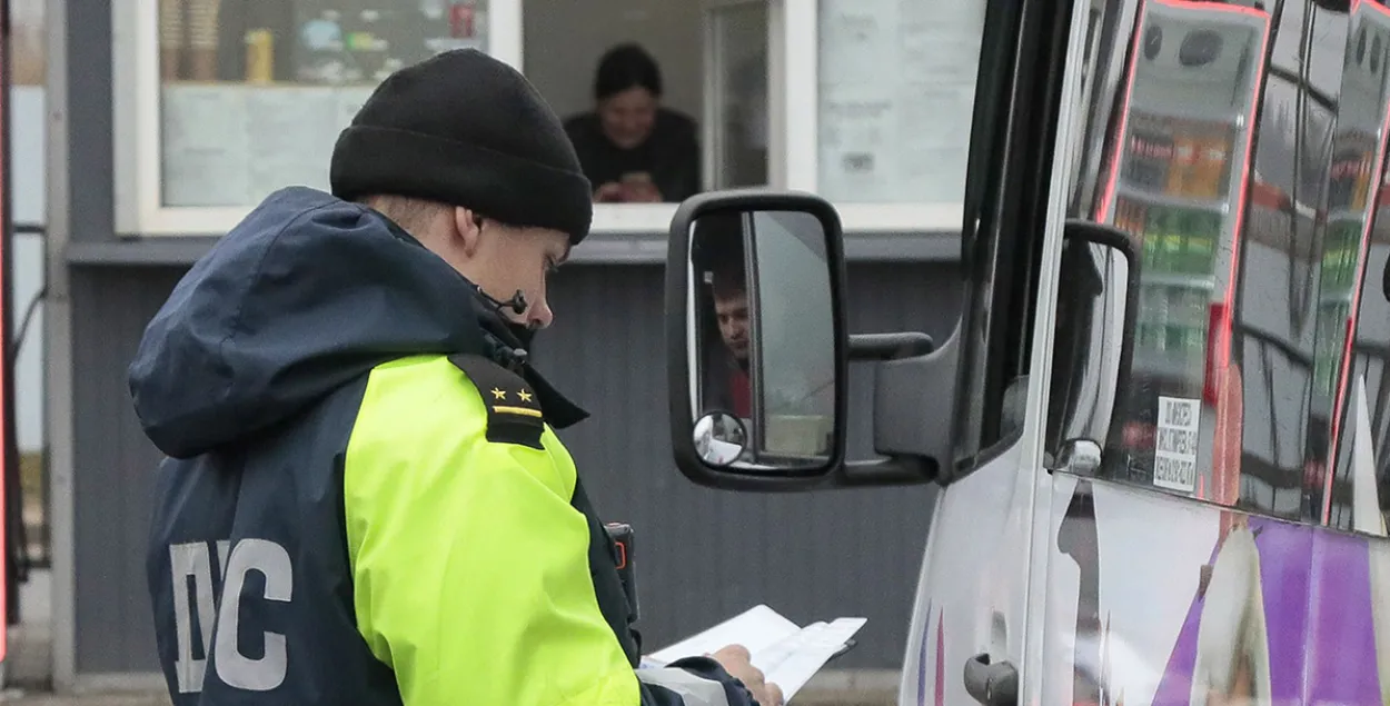 Сотрудник ДПС проверяет документы у водителя маршрутного такси
