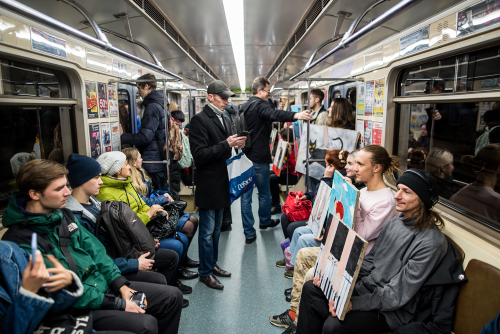 Белорусский художник сделал выставку в вагоне метро, одну из картин держит Бакей