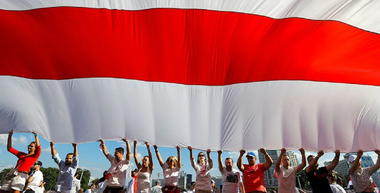 Белорусы с огромным бело-красно-белым флагом / АР
