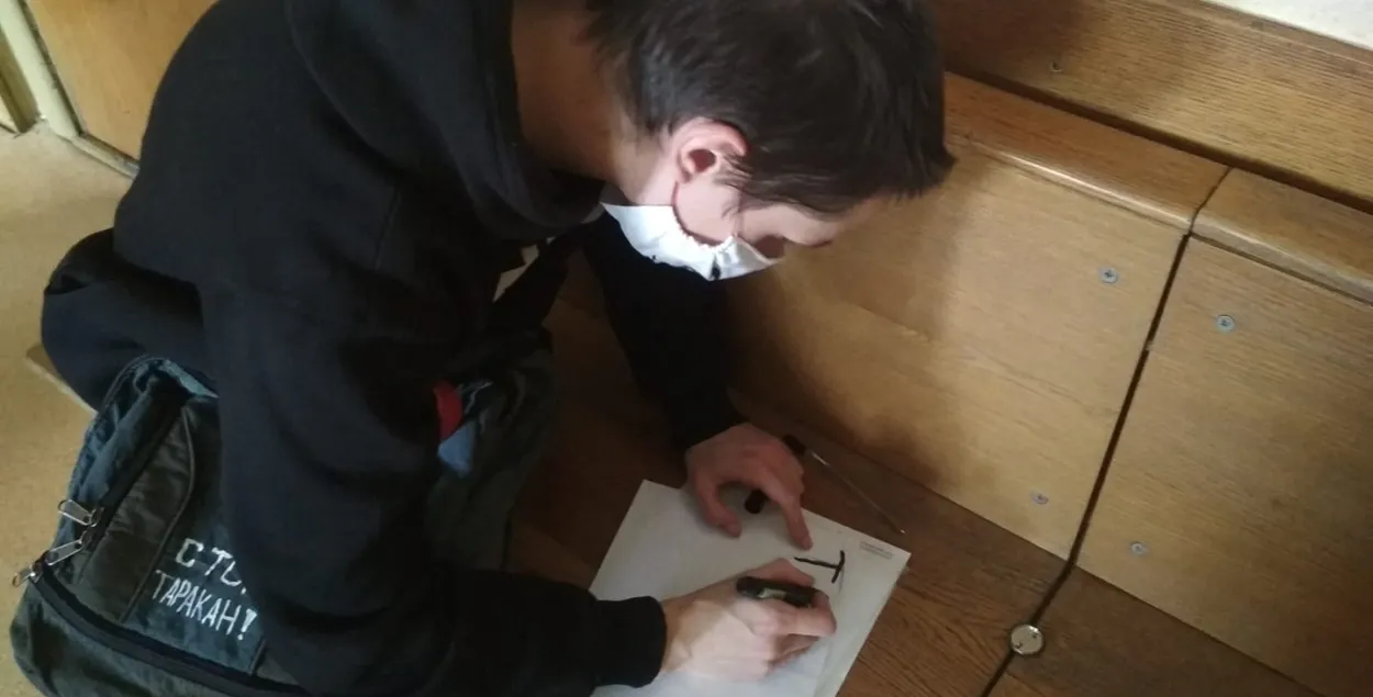 Дмитрий Полиенко в суде Первомайского района рисует плакат &quot;Таких, как я, 97%&quot;. До этого такой же сорвал милиционер / Фото из фейсбука Анастасии Полиенко