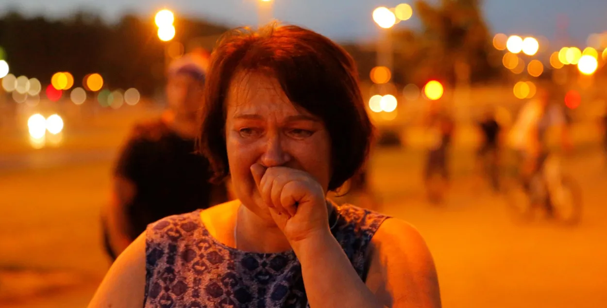 Женщина плачет во время разгона акции протеста в Минске / Reuters​