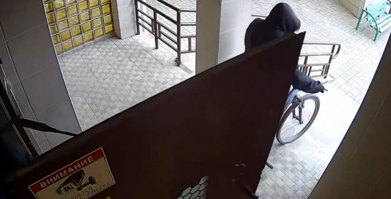 Украденный велосипед выносится из подъезда дома / Скриншот видео минской милиции

