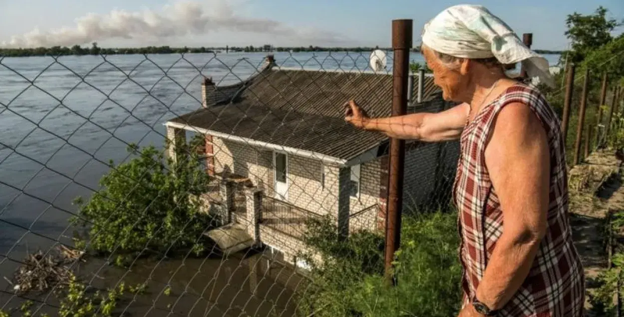 Жительница Новой Каховки на Херсонщине смотрит, как вода затапливает соседние дома / Reuters
