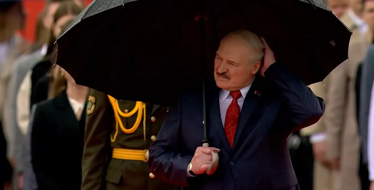 Александр Лукашенко пытается спрятаться под зонтиком / president.gov.by