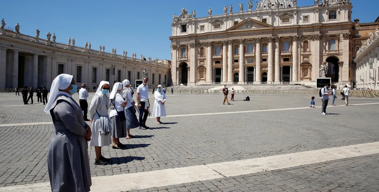 Верующие в защитных масках держатся на расстоянии во время молитвы Папы Римского из окна в Ватикане 31 мая 2020 года / Reuters
