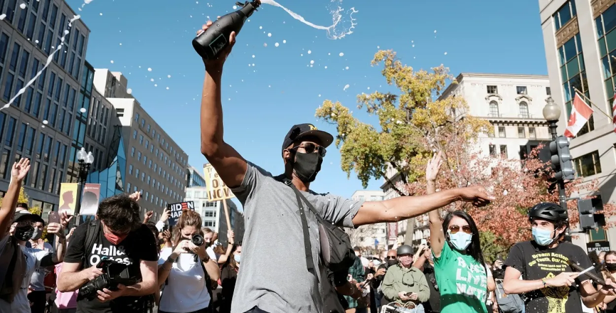 Жыхары Вашынгтона абліваюцца шампанскім пасля абвяшчэння вынікаў выбараў прэзідэнта ЗША 7 лістапада 2020 года / Reuters