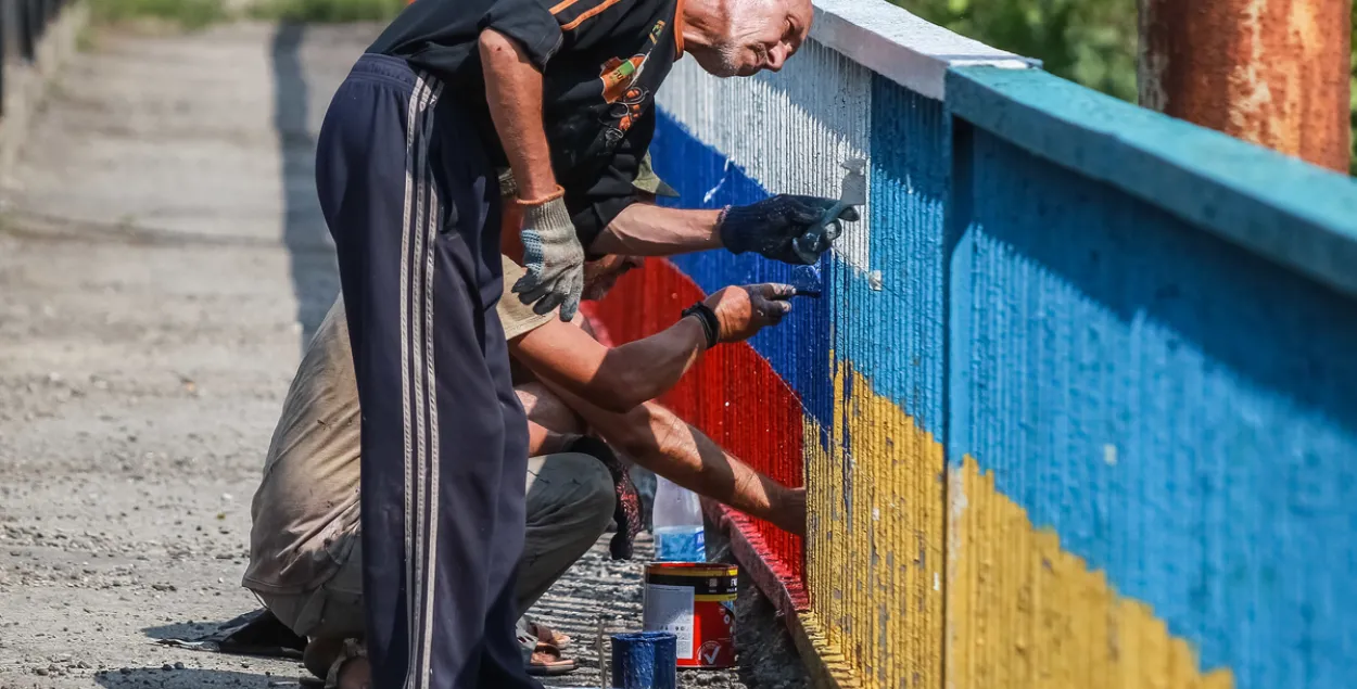 Мужчины перекрашивают мост в Украине / ura.ru
