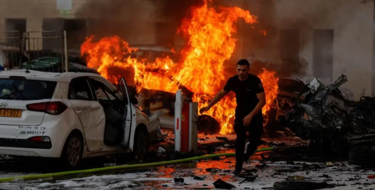 Мужчина убегает от огня после ракетного удара в Ашкелоне