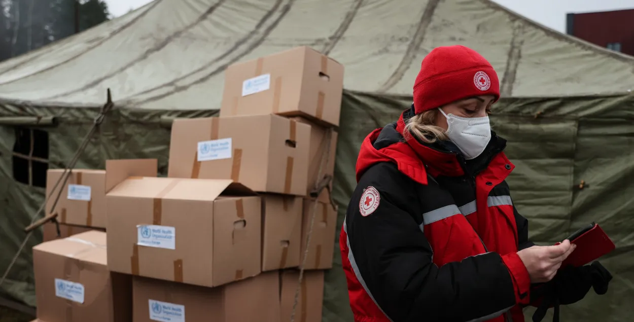 Работница белорусского Красного Креста рядом с гуманитарной помощью