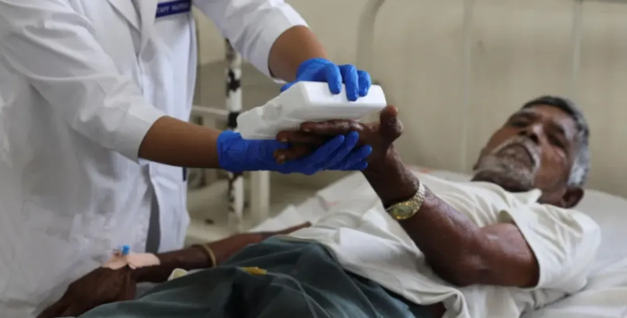 Медсестра помогает пожилому пациенту с тепловым ударом
