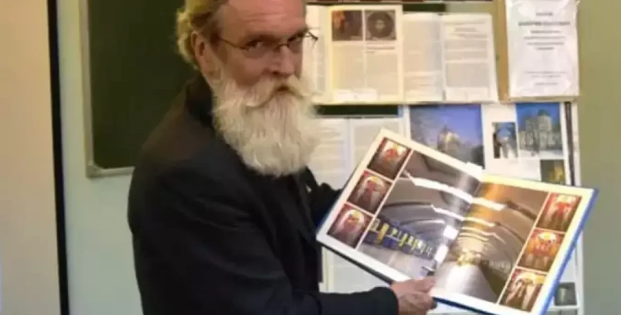Валерий Чайка держит в руках альбом со снимками станции метро"Институт культуры". Он работал над ее оформлением
