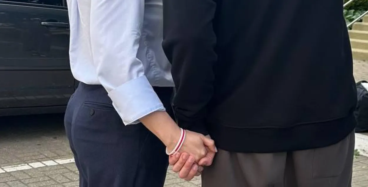 Светлана и Сергей Тихановские держатся за руки
