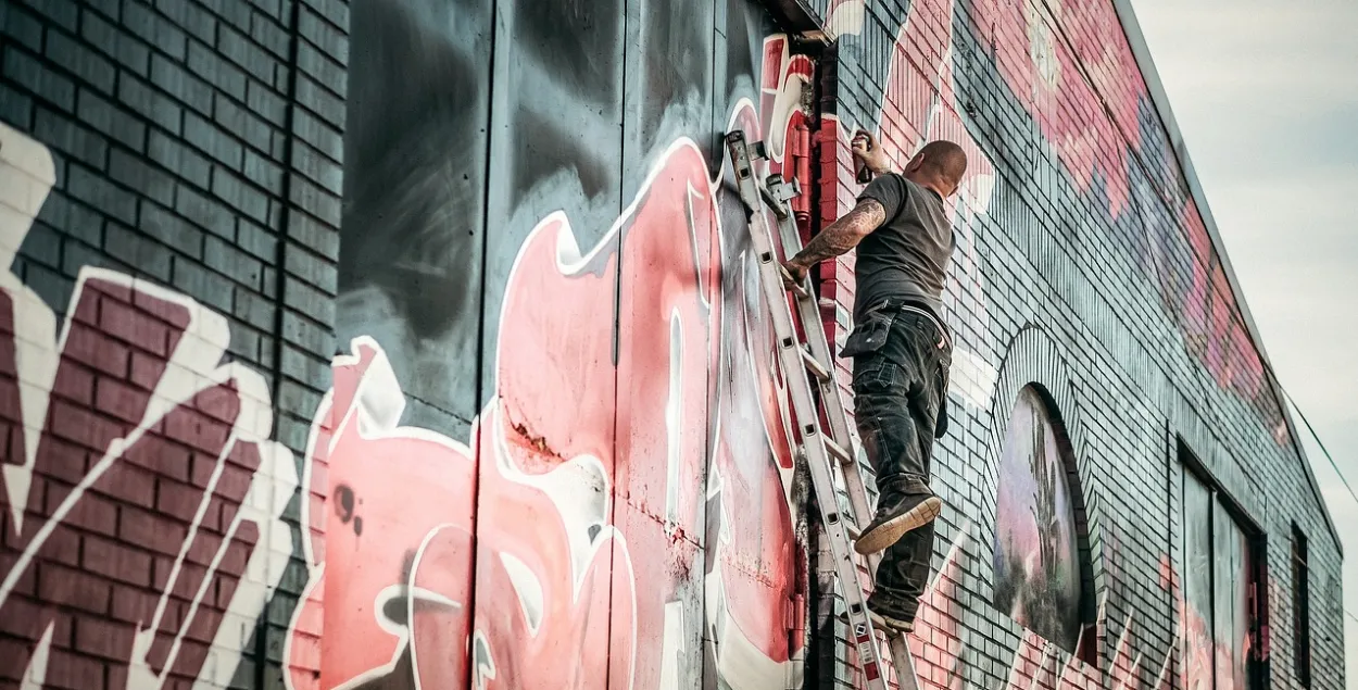 Мужчына, малюючы на сцене графіці
