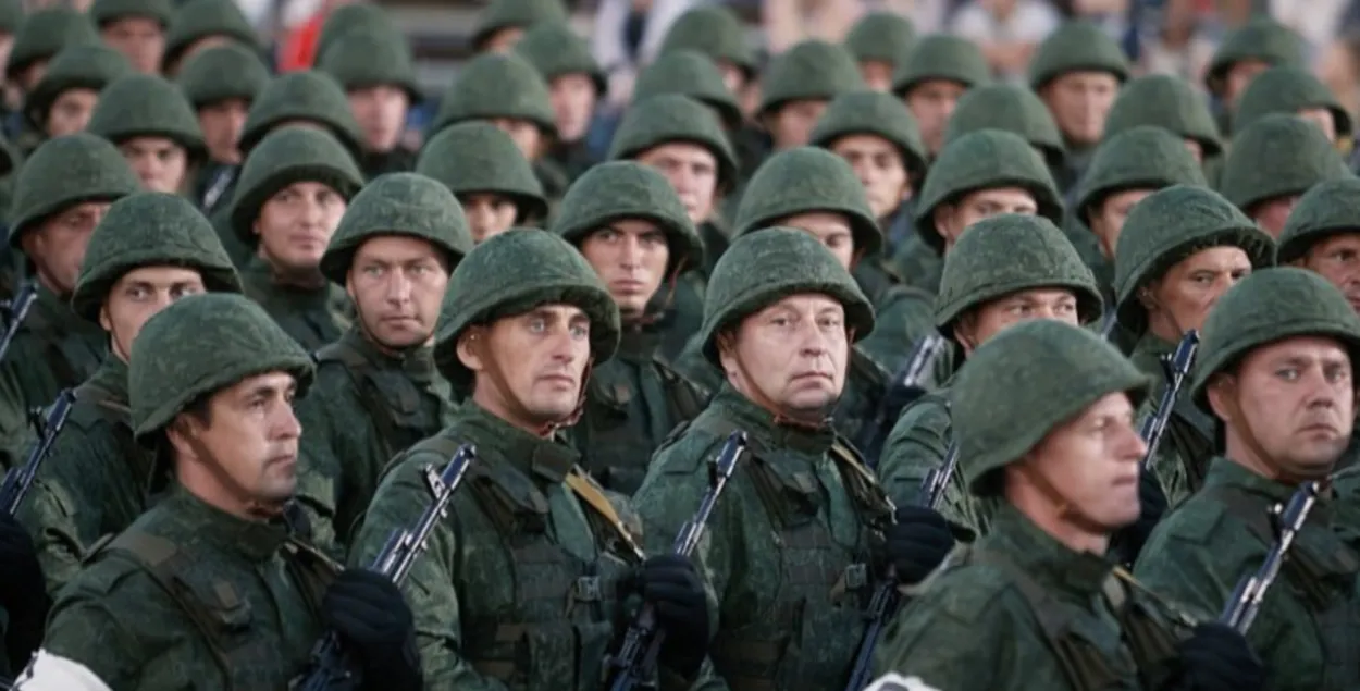 Шчыльны строй вайскоўцаў запасу ва ўніформе з аўтаматамі і ў касках падчас ваеннага парада
