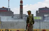 Российский военный на фоне второго и третьего энергоблоков ЗАЭС / Reuters
