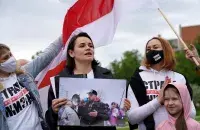Светлана Тихановская на уличной акции в Вильнюсе держала портрет своего мужа, который уже год за решёткой в Беларуси / Reuters​