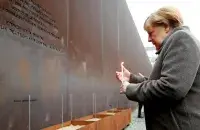 Канцлер Германіі Ангела Меркель запальвае свечку ля мемарыяла падзеленага горада і ахвяр камуністычнай тыраніі падчас цырымоніі, прысвечанай 30-годдзю падзення Берлінскай сцяны/ Reuters