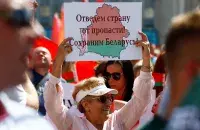 Жанчына трымае плакат на мітынгу ў падтрымку Лукашэнкі 16 жніўня 2020 года Reuters