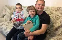 Андрей Шарендо с детьми и портретом Полины Шарендо / facebook.com/Andrei.Sharenda