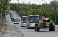 Автобусы с украинскими военными под конвоем российской бронетехники / Reuters​