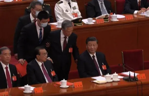 Бывшего лидера Китая&nbsp;Ху Цзиньтао выводят из зала, где проходит закрытие съезда Коммунистической партии Китая / скриншот видео BBC
