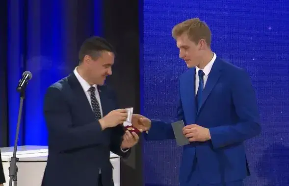 Николай Лукашенко (справа) на выпускном получает медаль из рук министра образования Андрея Иванца (слева)