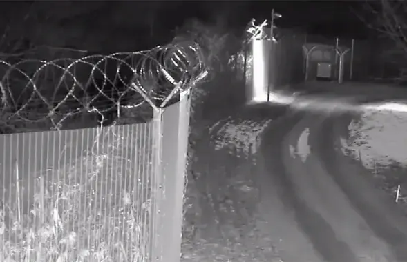 Неизвестный пытается сбить видеокамеру на литовской стороне границы / кадр из видео
