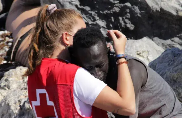 Волонтёрка &quot;Красного Креста&quot; обнимает сенегальца, который попал в испанскую Сеуту во время миграционной волны в мае 2021 года / murcianoticias.es