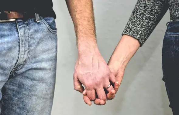 Мужчина и женщина держаться за руки