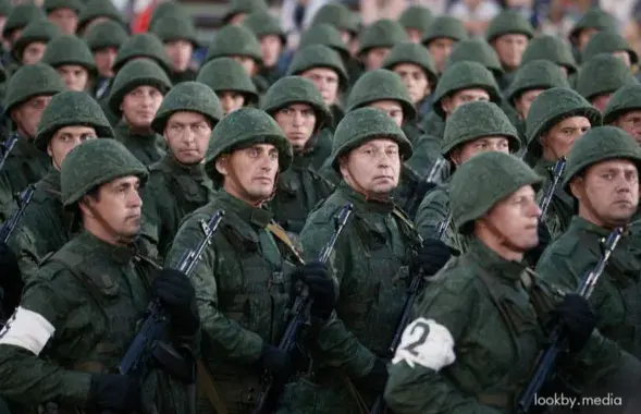 Шчыльны строй вайскоўцаў запасу ва ўніформе з аўтаматамі і ў касках падчас ваеннага парада
